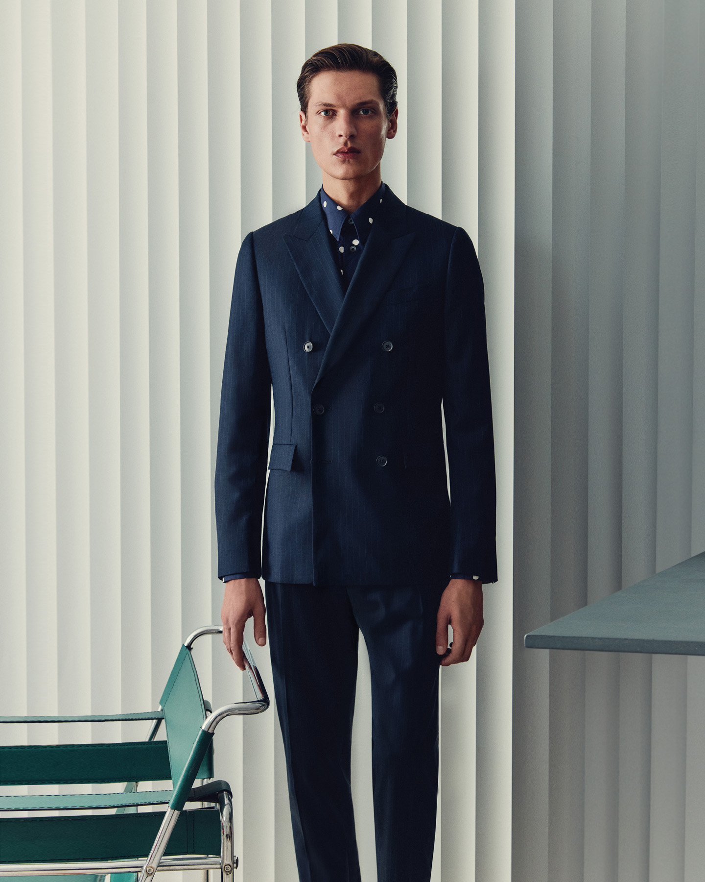 Male model wearing a navy Paul Smith double-breasted wool suit.